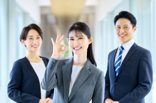 OKサインをする 女性と同僚.jpg